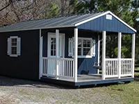 Blue and white portable cabin with front porch and metal roof