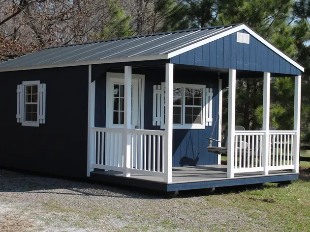 Blue and white portable cabin with front porch and metal roof